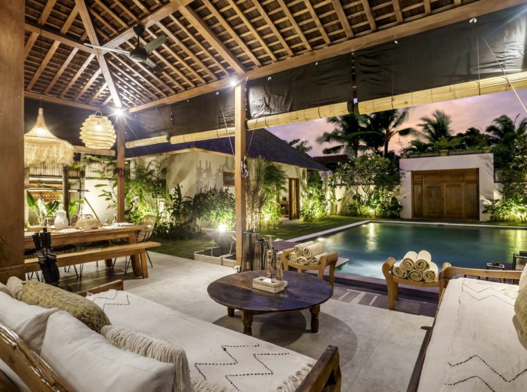 Semi-outdoor living space with couches overlooking the pool in 10 bedroom Seminyak villa