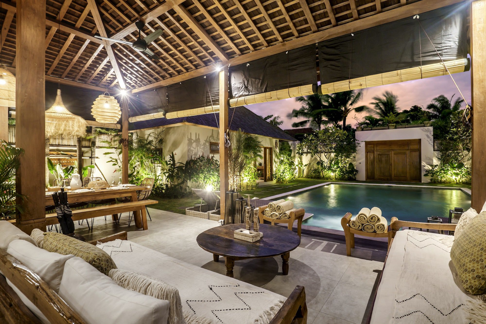 Semi-outdoor living space with couches overlooking the pool in 10 bedroom Seminyak villa