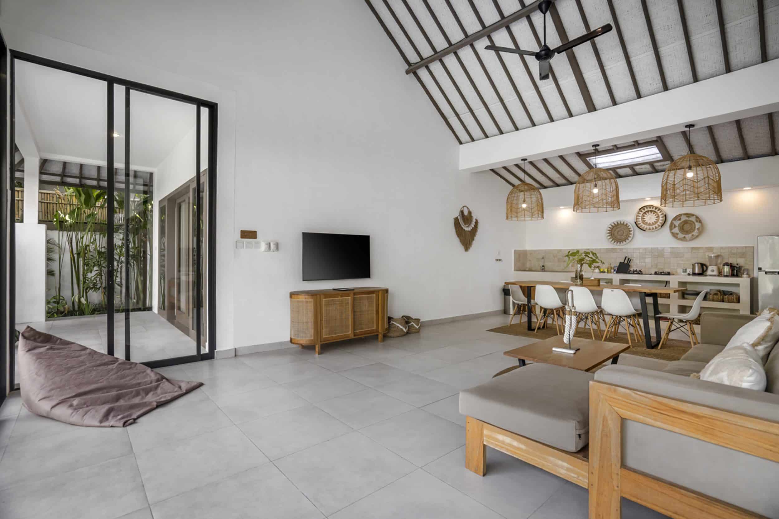 Villa Moju couch facing the TV with the kitchen in the background