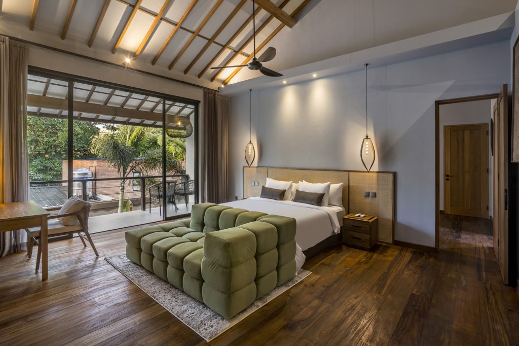 Pererenan Villa Sessun master bedroom with a green couch by the bed