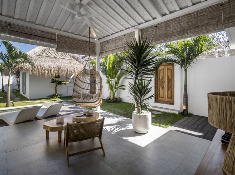 Villa Makena semi-open living room with a rattan hanging swing and a small wooden table with chair