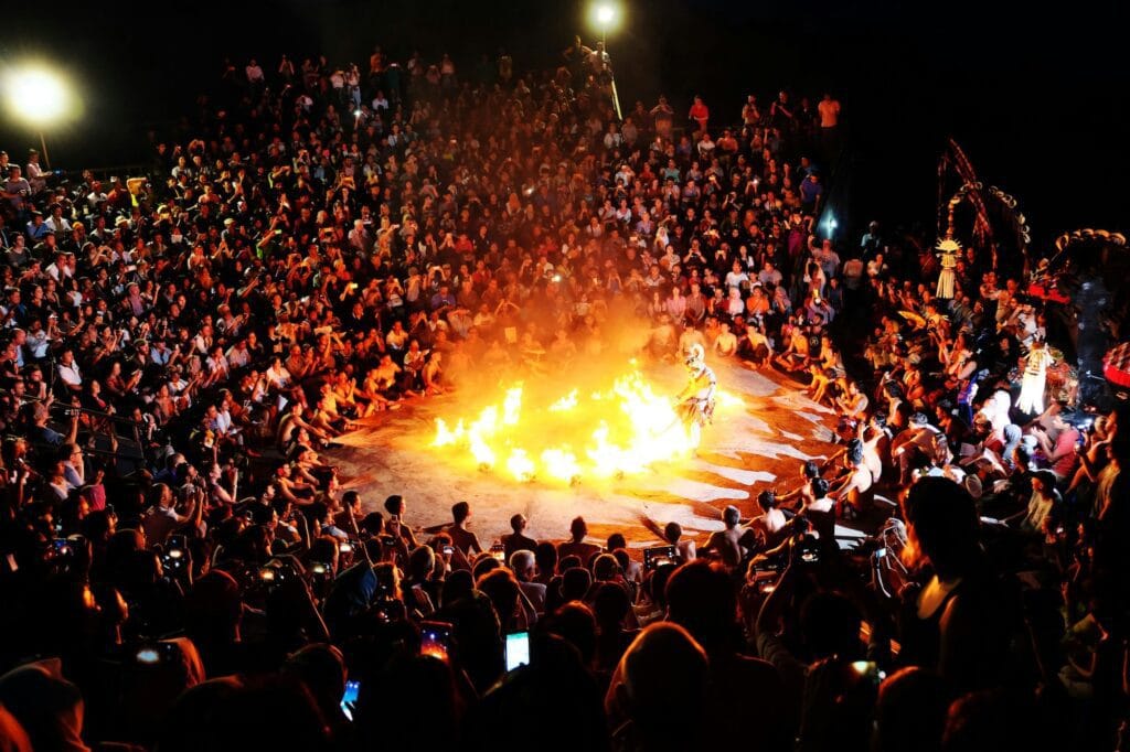 The traditional Balinese dance, Kecak, is being performed at nighttime with fire in front of a big crowd watching and is one of the family friendly activities in Bali you can do 