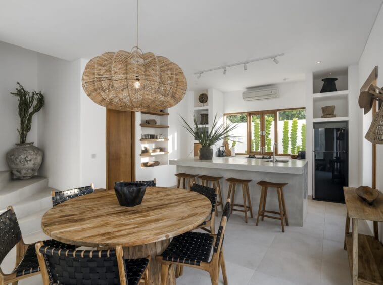 Wooden dining table with a fully equipped kitchen in the background