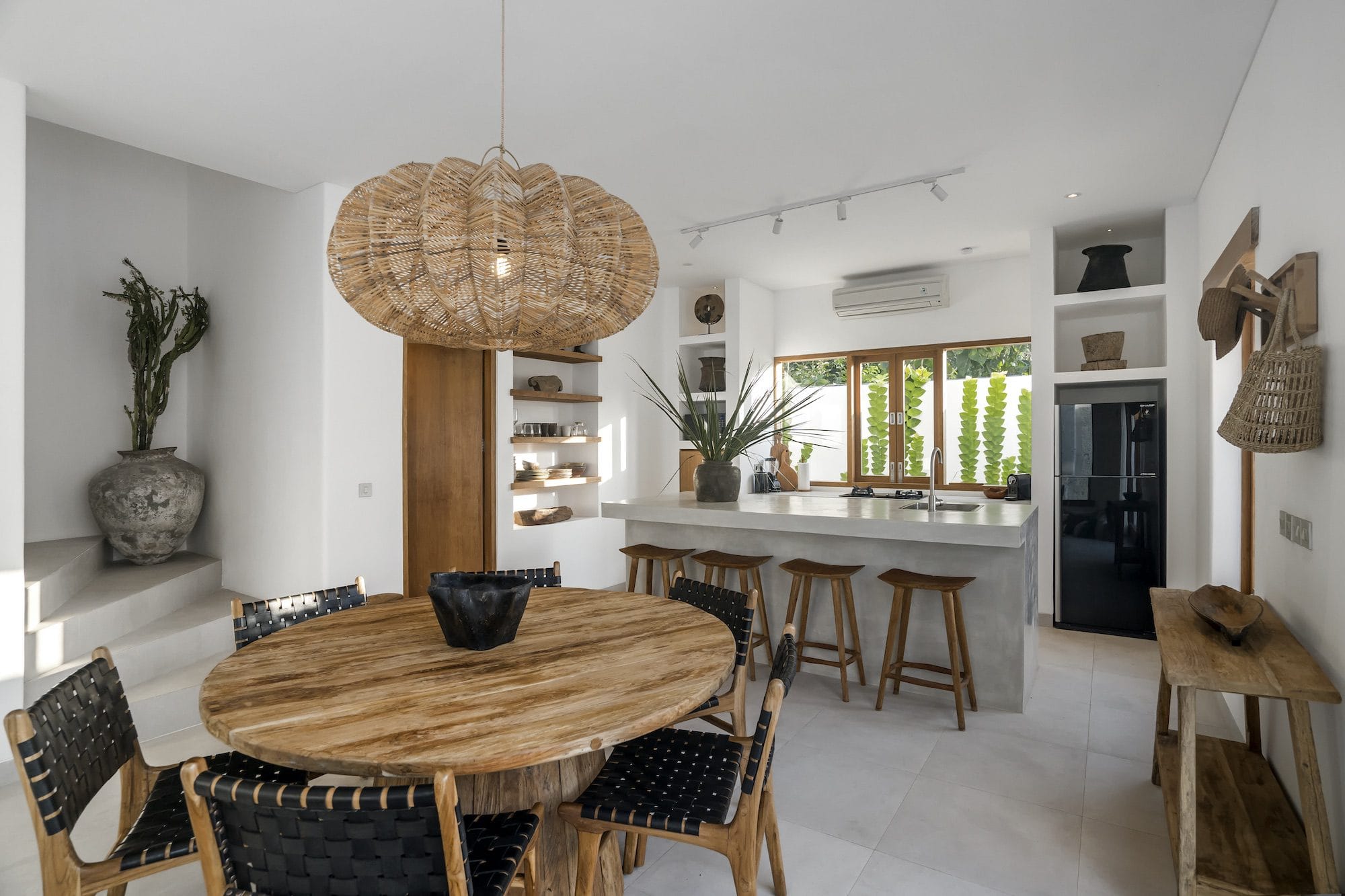 Wooden dining table with a fully equipped kitchen in the background