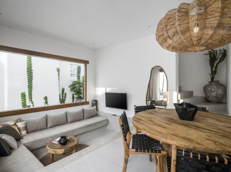 Living area with dining table and a sunken grey couch by the TV