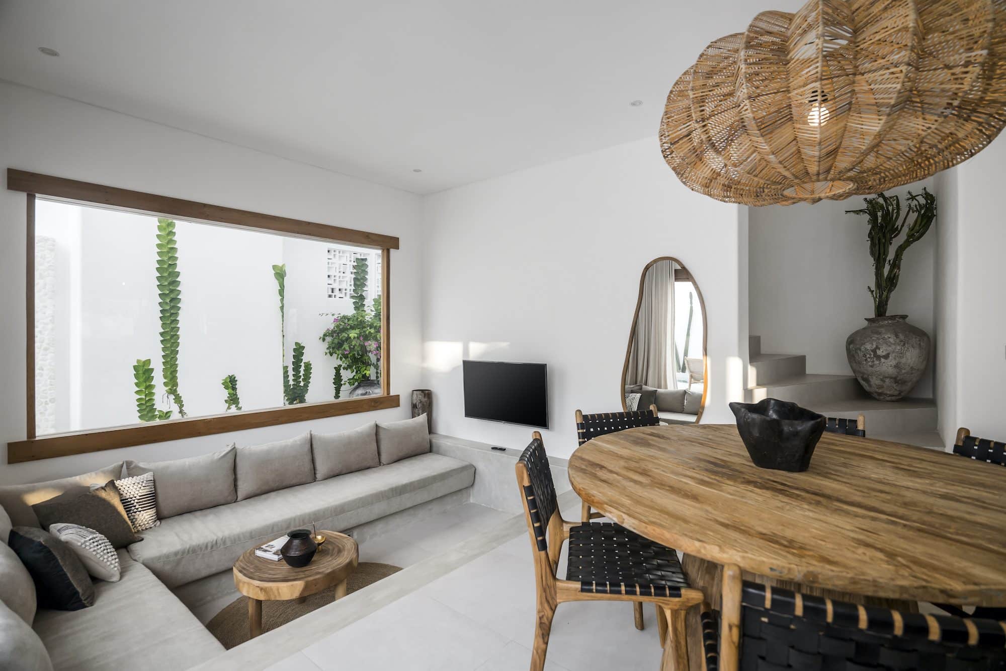 Living area with dining table and a sunken grey couch by the TV