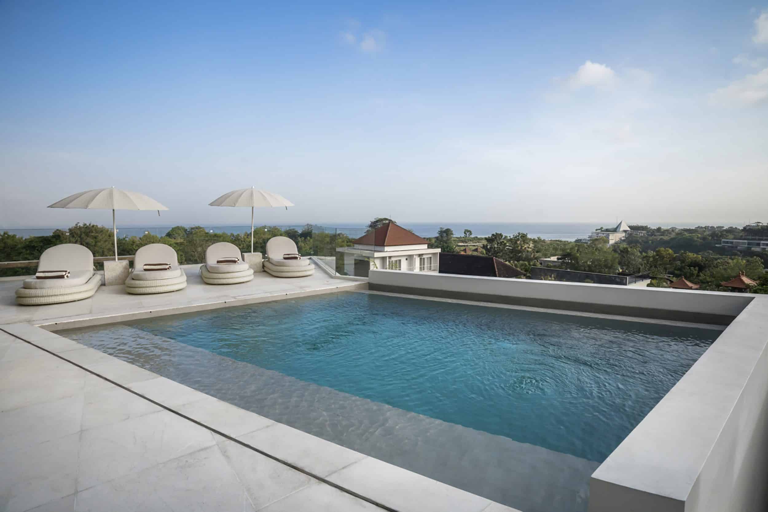 View from the pool of this private villa in Bingin with four sun loungers and ocean views