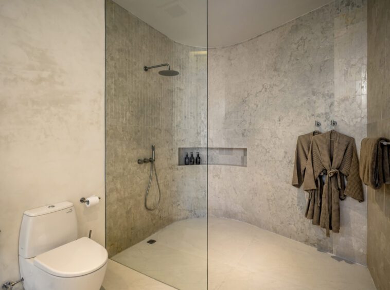 Bathroom with shower, robes and toilet at Namiko, a private villa in Bingin