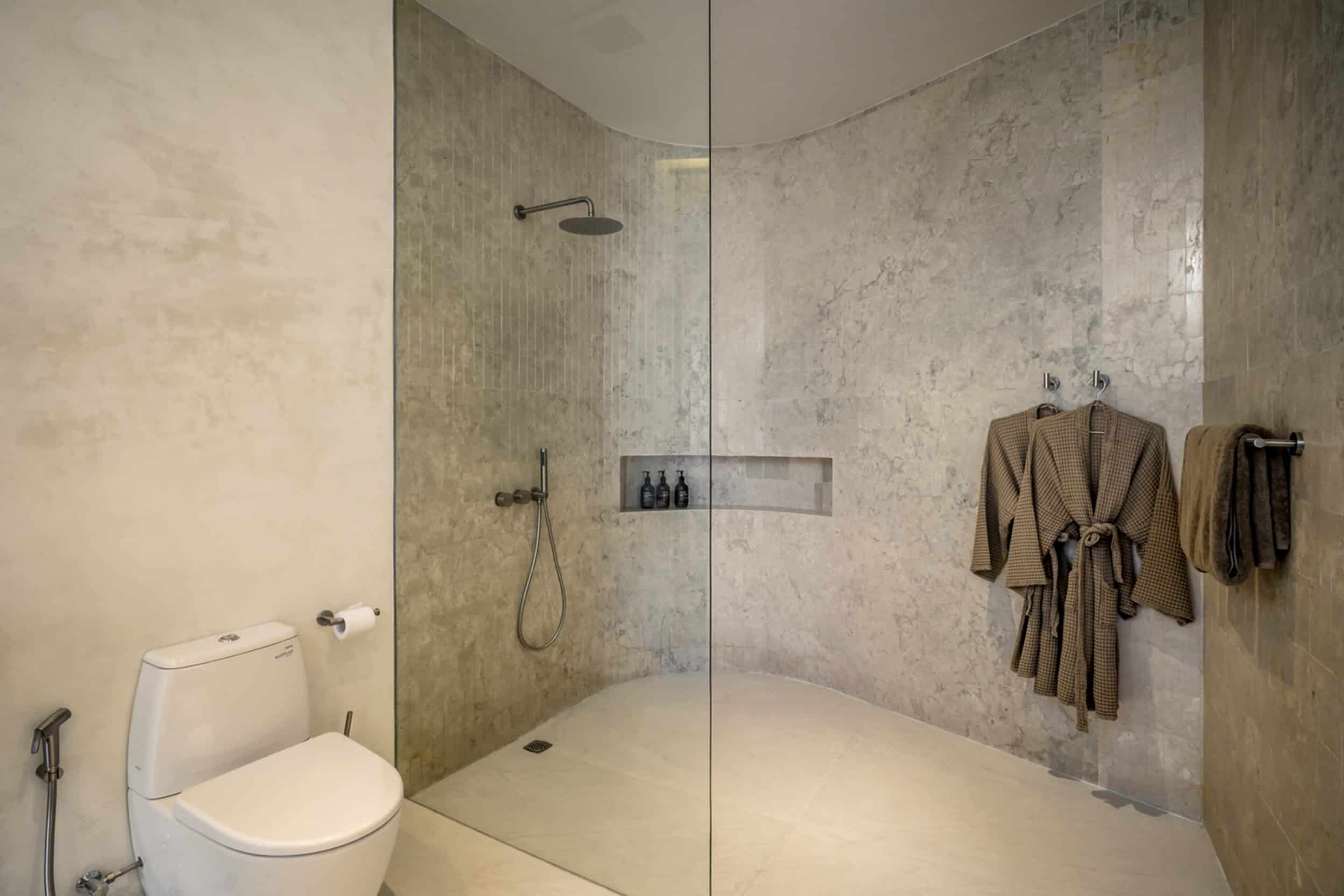 Bathroom with shower, robes and toilet at Namiko, a private villa in Bingin