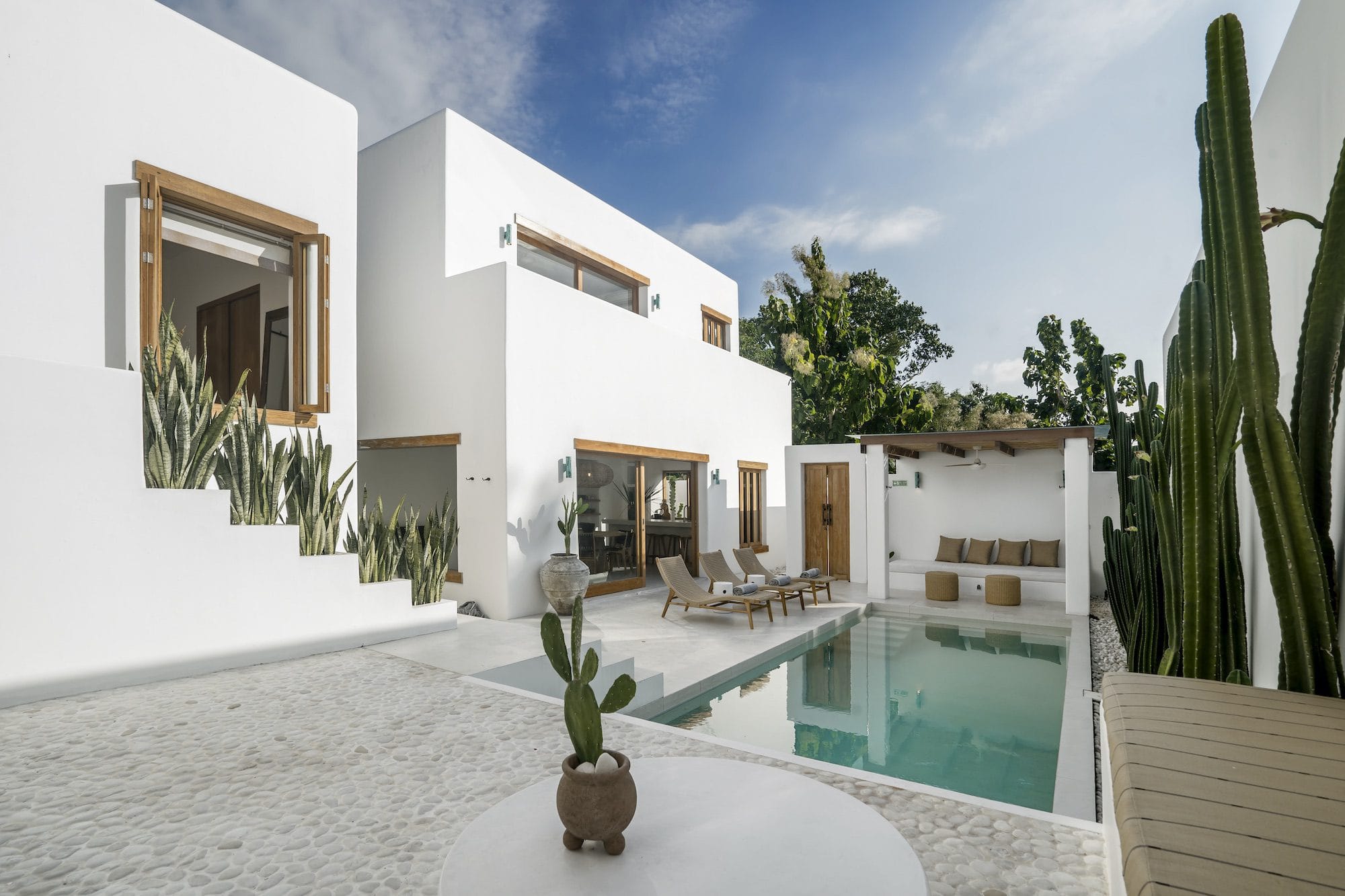 Outdoor area of a white private villa in Bingin with cactuses surrounding the pool