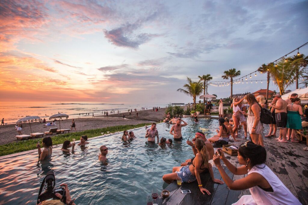 The Lawn day club in Bali crowded pool overlooking the beach and sunset