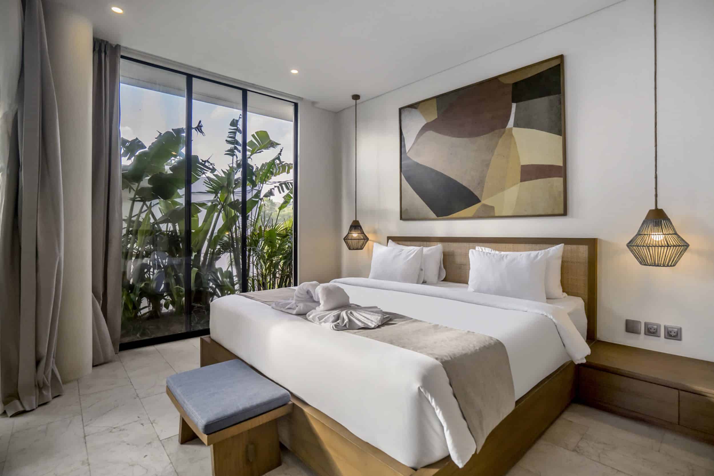 Bedroom in a Uluwatu villa with greenery outside the window