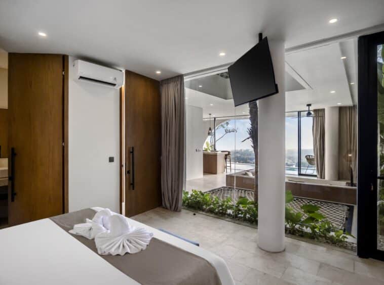 Bedroom in Uluwatu villa with TV and windows towards the living room